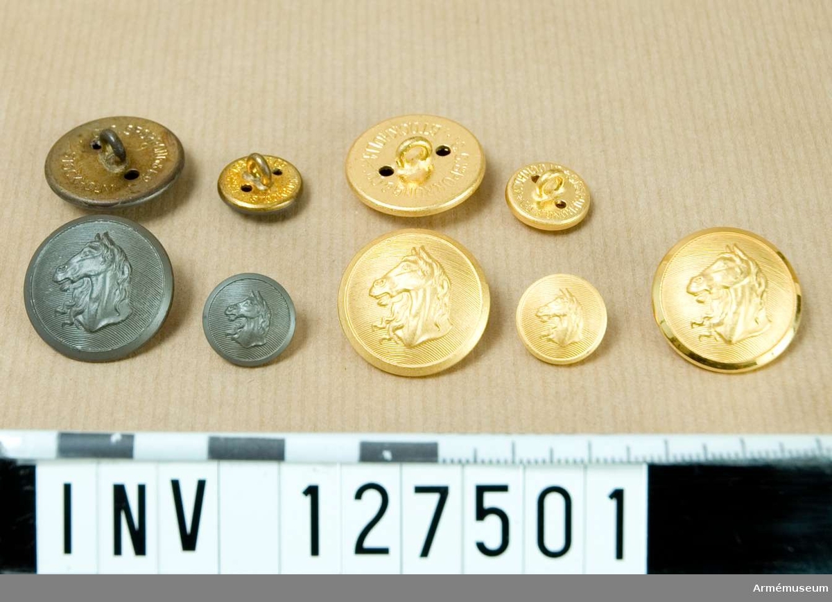 Låda innehållande stora och små knappar, guldfärgade och gråmålade. Av m/1876, m/1939 och m/1960.