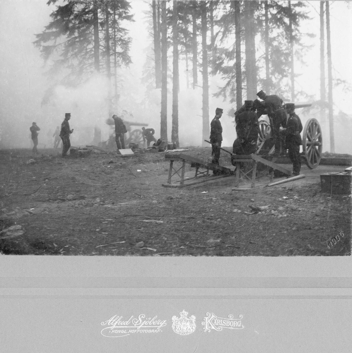 Soldater tillhörande Positionsartilleriregementet i Karlsborg övar med två positionsartilleripjäser i tallskog, tät krutrök eller dimma.