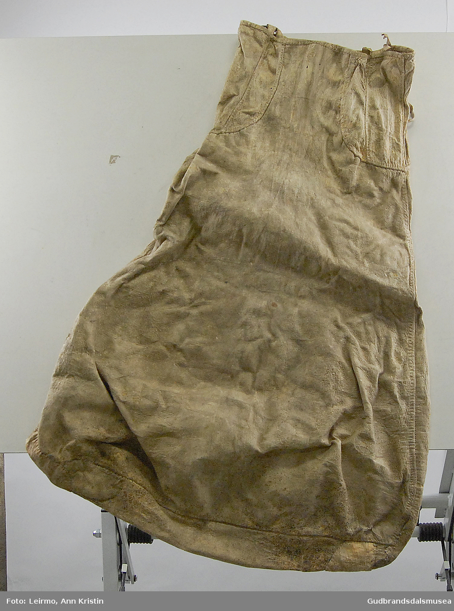 Pæreformet skinnpose med smalere åpning. Rester av skinnbånd ved åpningen. Fire smettekroker(?)