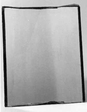 Spegel. På en tid då det var otänkbart att Postverket skulle
kunna köpa en spegel för tjänstemännen samlade en del postexpeditörer
till en sådan enkel spegel. Text enligt MRK på baksidan. Spegeln
består bara av ett rektangulärt glas.