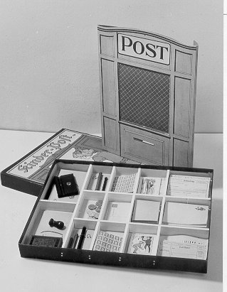 Barnpost i pappkartong innehållande miniatyr
stämplar,frimärken, postblanketter mm. På kartongens omslag står
text:"KinderPost".