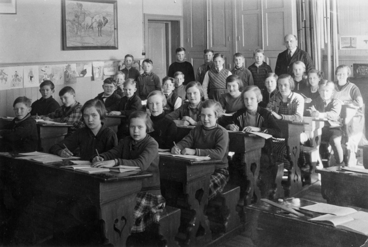 Gruppfoto med flickor och pojkar i klassrummet på Gamla Fässbergsskolan. Magister Daniel Nilsson med elever. 5:e - 6:e klass. Radion på väggen har eleverna samlat in pengar till.

Fässbergsskolan låg i sydvästra Solängen och var en av Mölndals tre äldsta skolor, byggd i början av 1860-talet. Byggnaden brändes ned 1971.