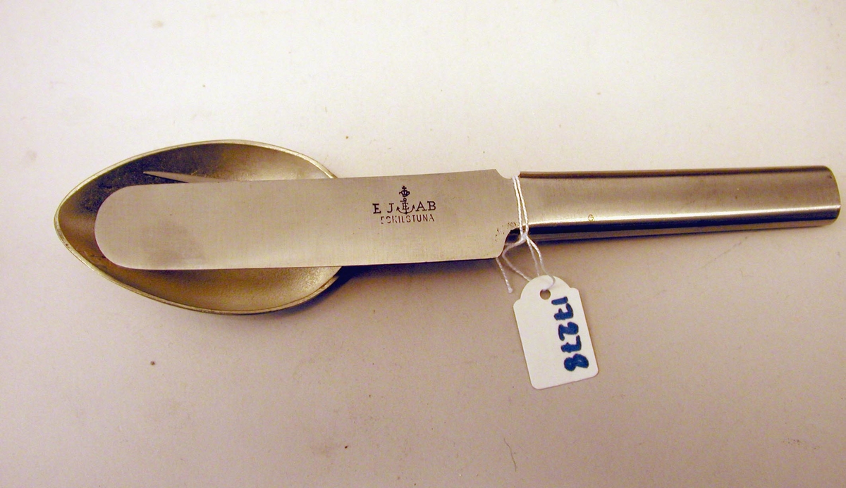 Bestickset bestående av en sked, gaffel och en kniv som kan
fogas i varandra genom att skjuta in gaffeln i skeden och kniven i
gaffeln. Inskription på kniven EJ AB Eskilstuna samt ett krönt ankare
med ett E.