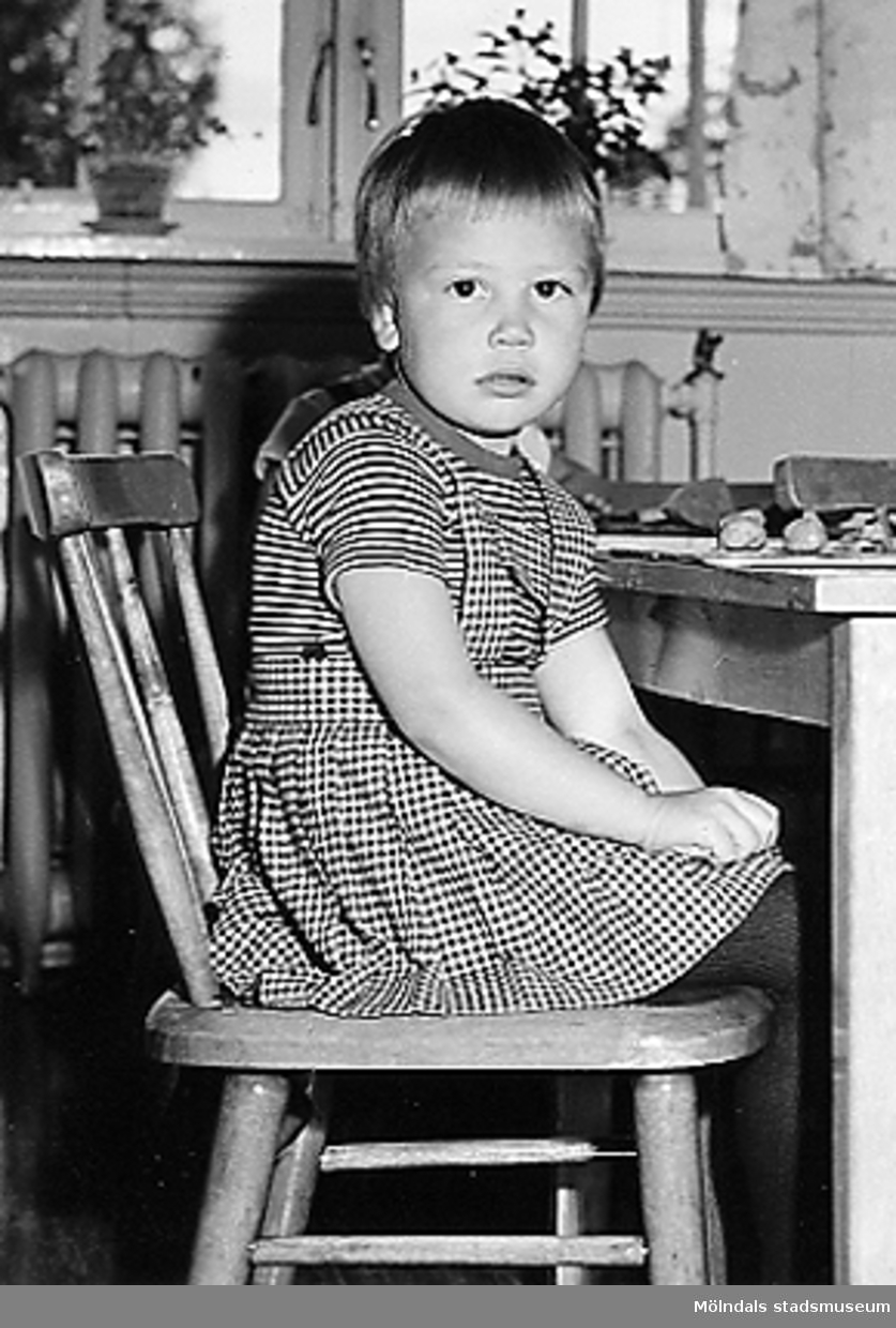 En flicka som sitter på en stol vid Holtermanska daghemmet 1953.