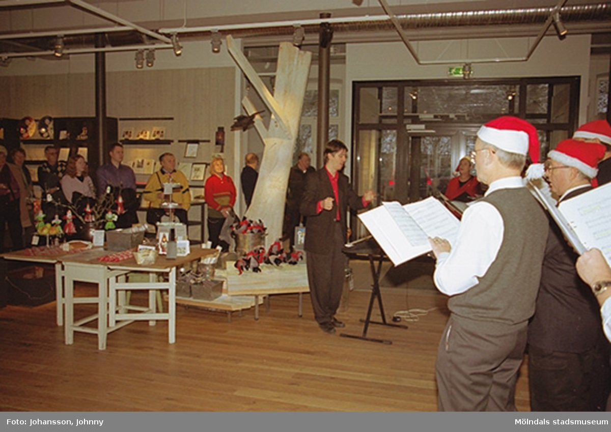 Besökare underhålls av Opus sångkör som sjunger på Mölndals museum 2002-12-15. Tomteutställningen: 30/11-02 - 1/1-03.