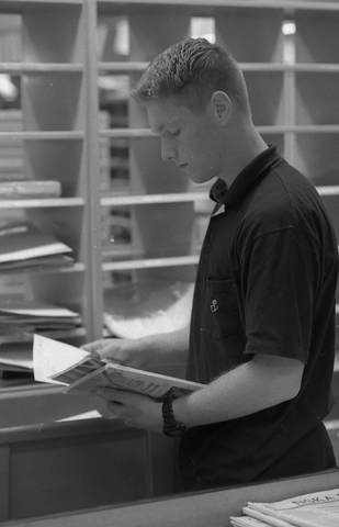 En posttjänsteman sorterar post inne i sorteringsdelen på en
postanstalt. Tillhör en dokumentation av en lantbrevbärare i trakten
av Valdermarsvik av fotograf Ove Kaneberg.