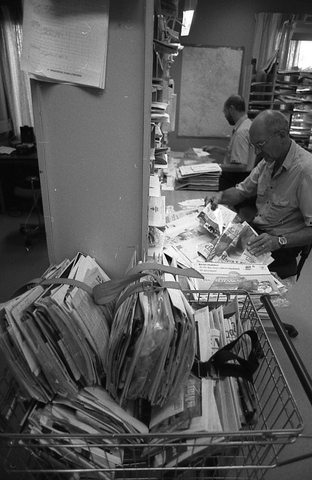 Lantbrevbärare Reinhold Andersson med flera posttjänstemän,
sorterar post inne i sorteringsdelen på en postanstalt. Tillhör en
dokumentation av en lantbrevbärare i trakten av Valdermarsvik av
fotograf Ove Kaneberg.