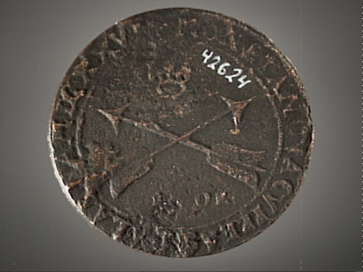 Ett runt kopparmynt, s k rundmynt, med valören 1 öre.

På myntets åtsida är det svenska riksvapnet svagt synligt. Omskriften med Gustav Adolfs regenttitlar är svagt synlig. Åtsidans prägling är ocentrerad.
På myntets frånsida syns två korsade pilar under en krona. Under pilarna är siffran 1 och versalerna ÖR svagt synliga. Omskriften på latin, med bland annat präglingsåret 1627 i romerska siffror, är delvis läslig.
Frånsidans prägling är centrerad.
Myntets vikt uppgår till 22,8 gram.
Myntets bägge sidor är slitna.

Text in English: Round coin. Denomination: 1 öre.
The obverse side has the Swedish coat-of-arms in the centre which is faintly visible. The legend has the regent titles of Gustav Adolf. The titles are faintly visible.
The coin stamp is off-centre.
The reverse side shows two crossed arrows beneath a crown. Under the arrows is the numeral 1 and the initials ÖR, which appear in capital letters, faintly visible. The legend has a Latin inscription and the date of coinage, 1627, in Roman numerals. The Latin inscription on the legend is faintly visible.
The coin stamp is centred.
Present condition: both sides are worn.
Weight: 22,8 gram.