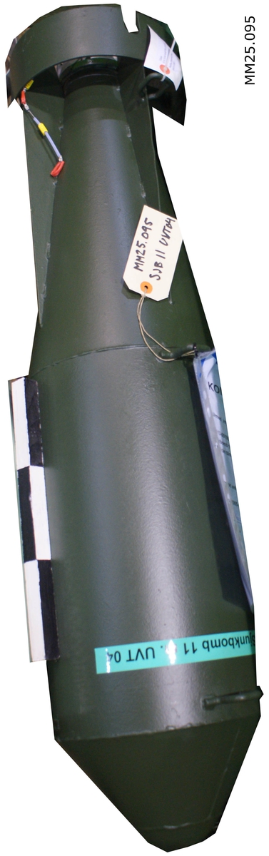 Grönmålad raketliknande sjunkbomb. I bakre änden sitter en Undervattenständare 06 med en graderad vridratt på vilken djup för explosion ställs in.

På en grön klisterremsa finns text: "Blind sjunkbomb 11 m UVT 04".