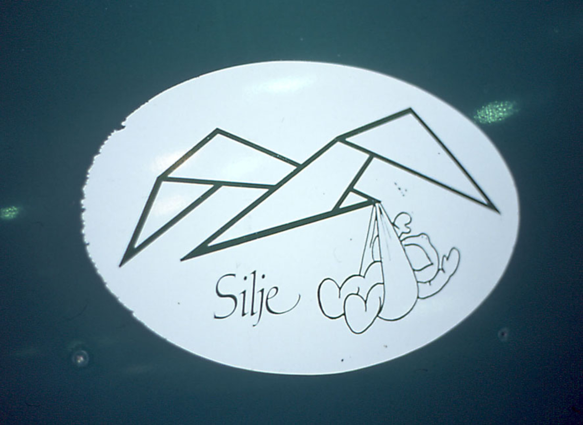 Detaljfoto av "logo",  lite barn, "Silje" på ett fly, LN-WFF, fra Widerøe.  .