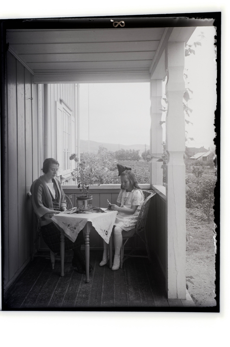 To kvinner på en veranda sittende ved et bord.