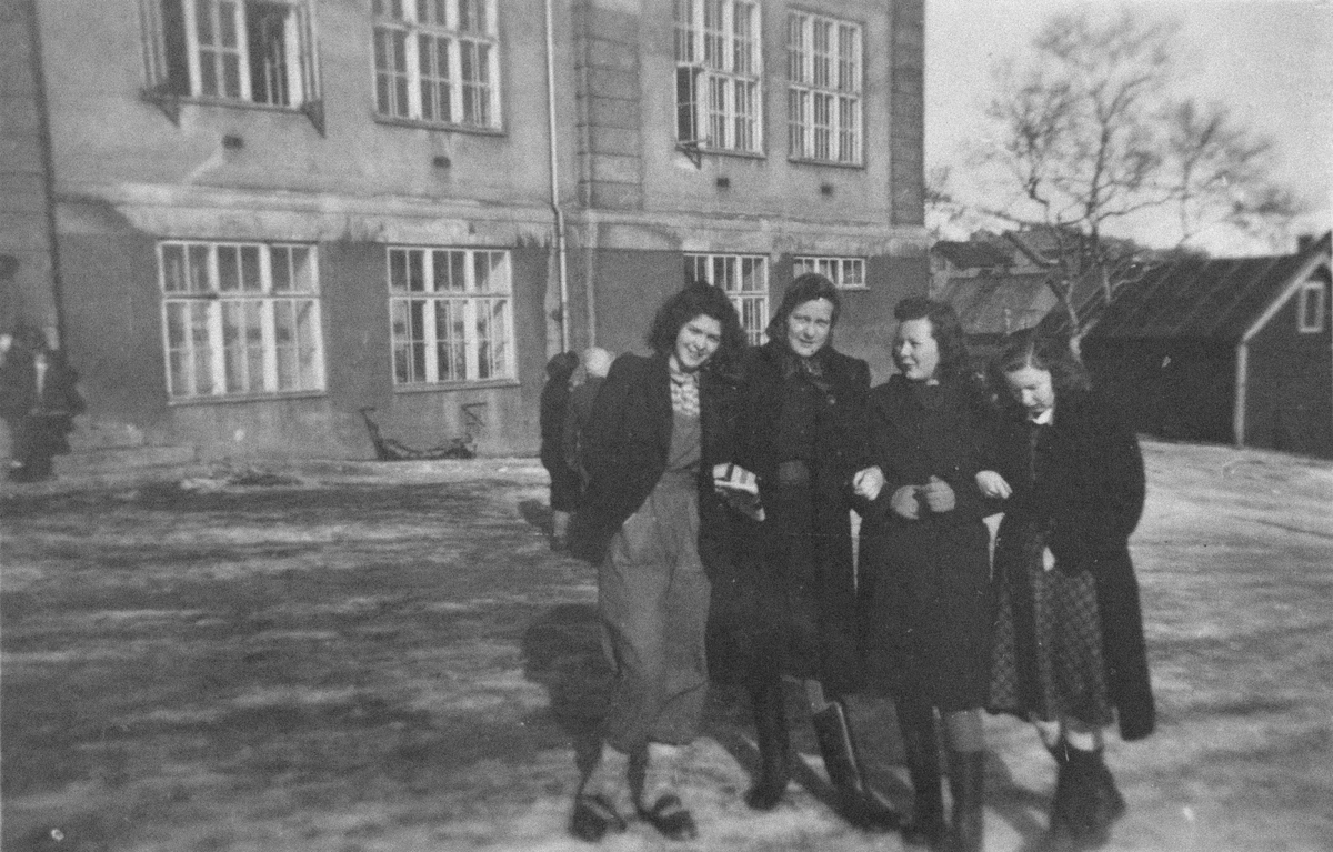Fire unge kvinner i skolegården ved byskolen.
