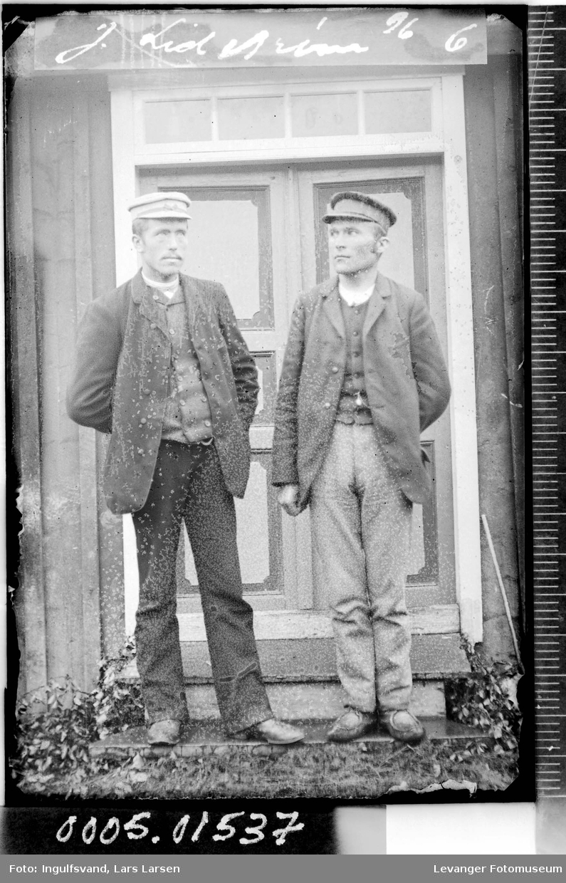 Portrett av to menn foran en dør.
