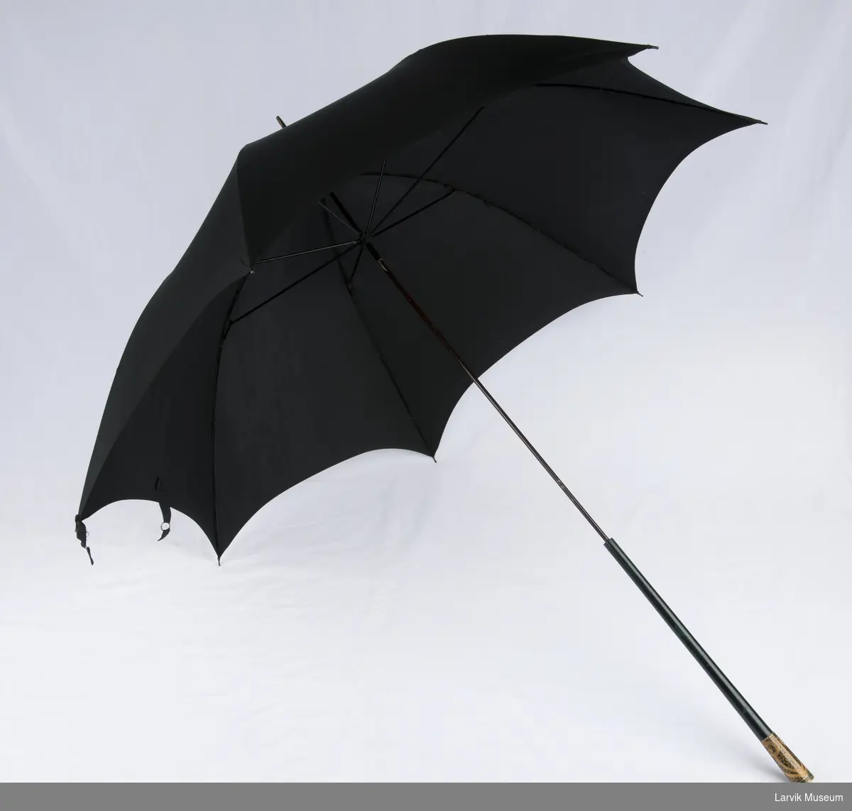 Sort parasoll med overtrekk. Pyntet skaft