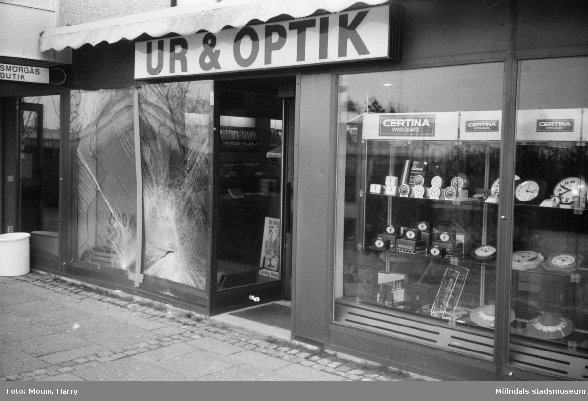 Inbrottsdrabbad ur- och optikaffär i Lindome centrum, år 1983. "Skyltfönstren krossades i Lindome-butiken då bilen backade in i dem."

För mer information om bilden se under tilläggsinformation.