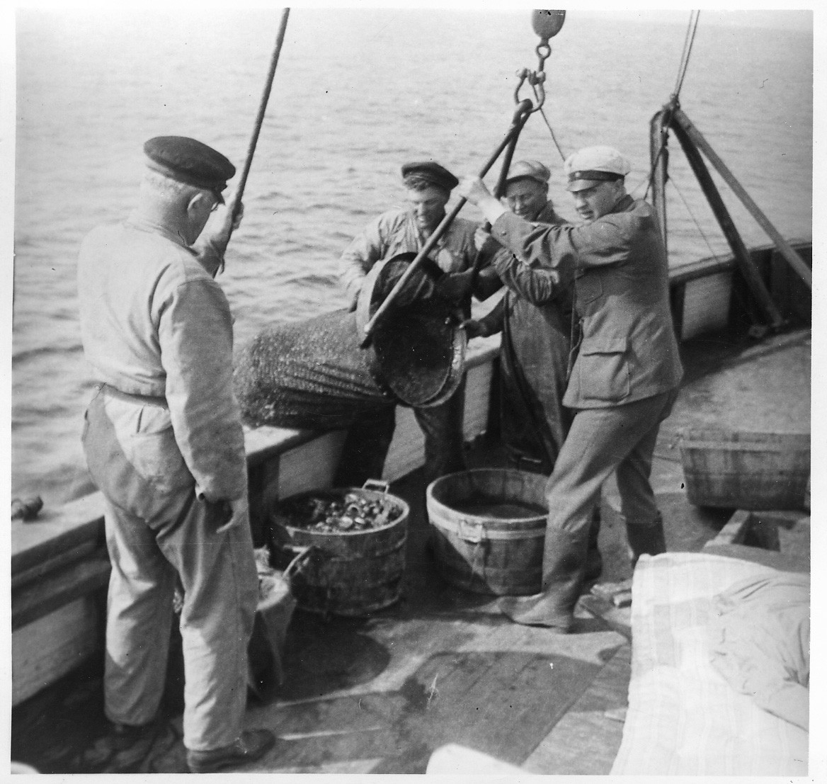 'Akka-expeditionen sommaren 1931: ::  :: 4 st män på Skandias båtdäck. Leonard Axel Jägerskiöld med ryggden mot kameran. De 3 andra männen arbetar med att tömma ringskrapan. ::  :: Ingår i serie med fotonr. 2182-2234.'