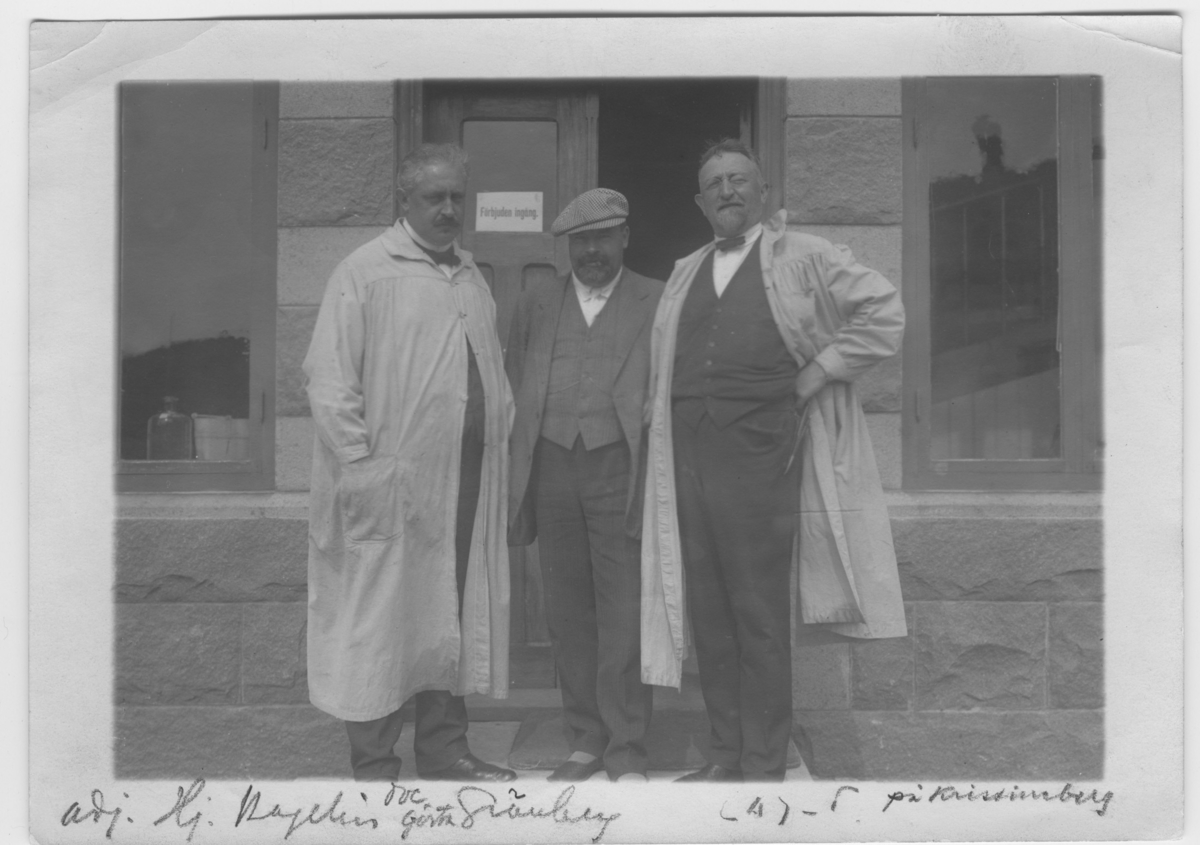 Läroverksadjunkten  Hjalmar Hagelin (längst till vänster), doc. Gösta Grönberg (i mitten) och prof. Leonard Axel  Jägerskiöld på Kristineberg. Framför dörr.