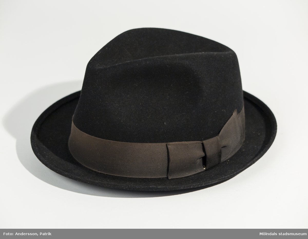 Svart hatt i stl. 57 av sammet med ett sidenband runt om.
Hatten är inköpt på Bröderna Petterssons herrekipering i Mölndal, före 1972.