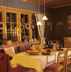 Et julepyntet vindu og et bord med kaker og te. Illustrasjon