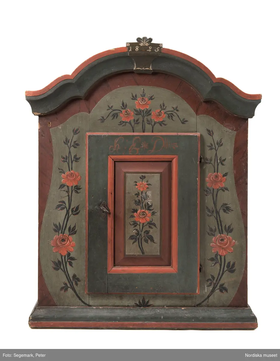 Katalogkort:
"av furu med 1 dörr, lås och nyckel, profil. fylln. med blommor i svart och rött mot grönt, röda och gröna lister, märkt: H. E. D. 1825."