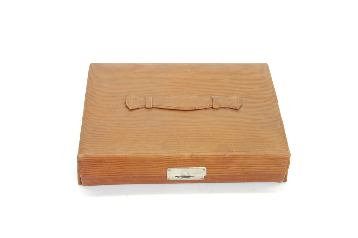 Form: rektangulær veske/koffert (smykkeskrinfasong) med mange små flasker og skrin samt en kles-/skobørste
