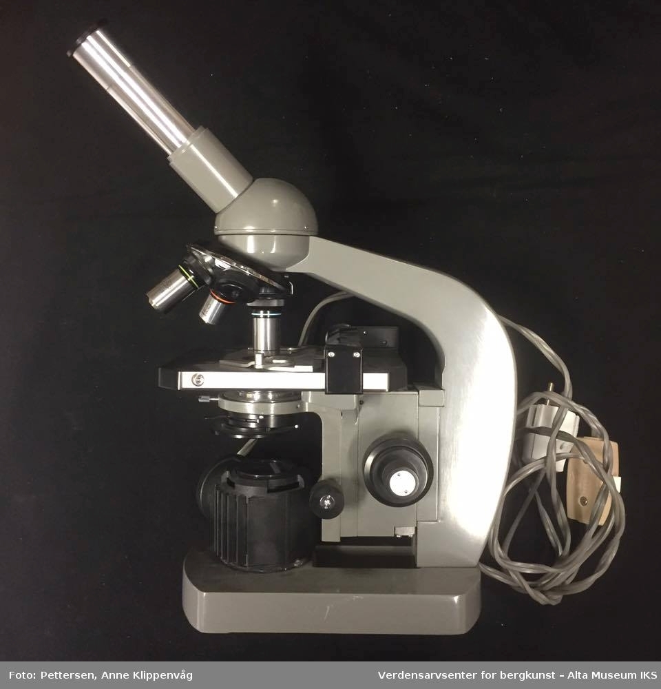 A: Trekasse, med bæreåndtak festet på oversiden. Inneholder et mikroskop, en ekstra trebunn som beskytter mikroskopet, og en liten trekasse med ekstradeler til mikroskopet. Kassen står på fire gummiknotter. 

B. Mikroskop. Et grålakkert mikroskop, av merket Olympus. Elektrisk, med innebygget lampe.