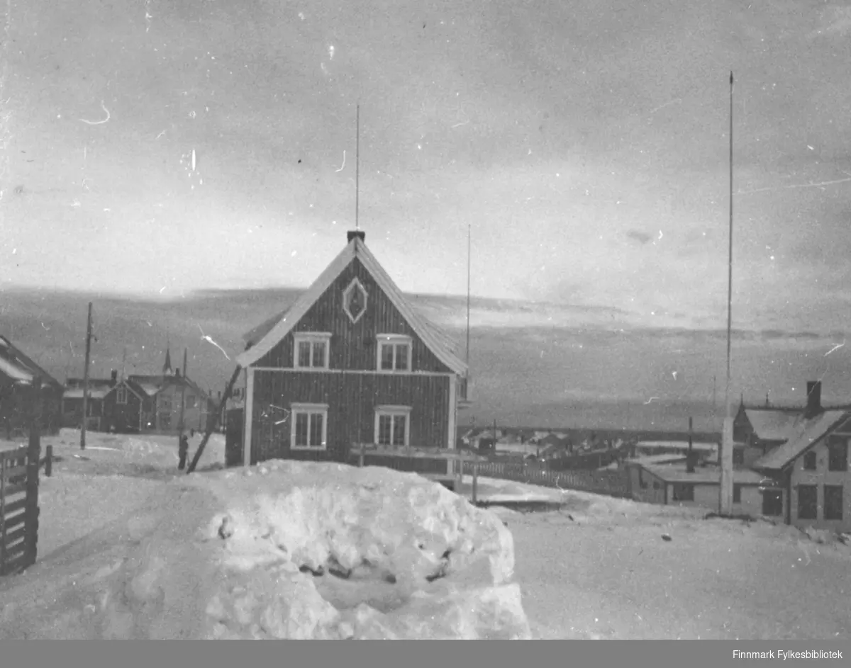 Et vinterbilde fra Damsveien i Vadsø. Huset midt i bildet tilhørte Harald Hofseth. Den store bygningen til høyre i bildet er Esbensens sveitservilla. Begge disse husene overlevde 2. verdenskrig, selv om Hofseths hus ble bombeskadet. Foran i bildet en snehule