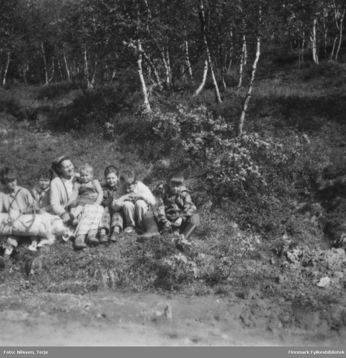 Bestemor Marie Sivertsen sammen med seks av barnebarna, i Øvre Neiden 1957