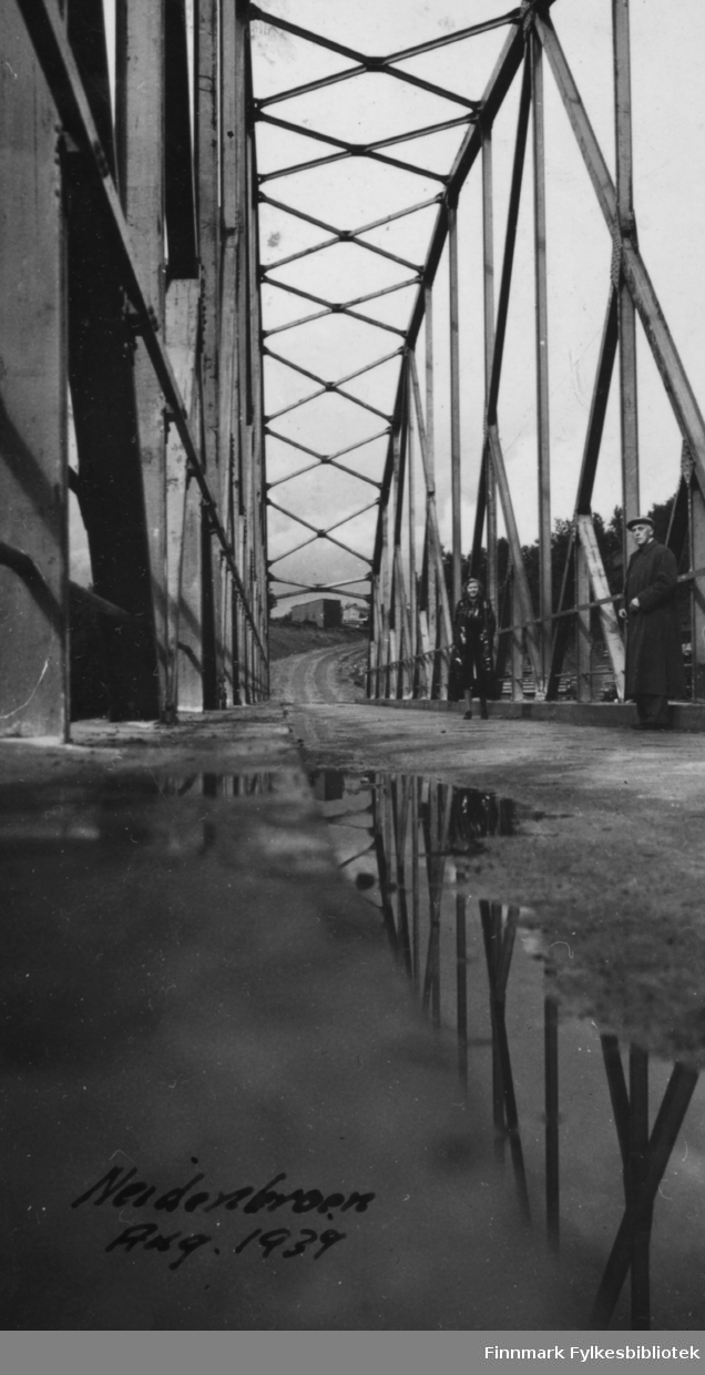 Bro over Neidenelva fotografert i august 1939. To ukjente presoner står på broa, en kvinne og en mann