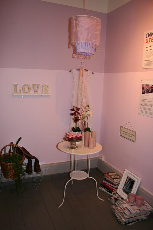 Et romantisk og rosa interiør med cup cakes, blondekjole på veggen, orkideer og duftlys.