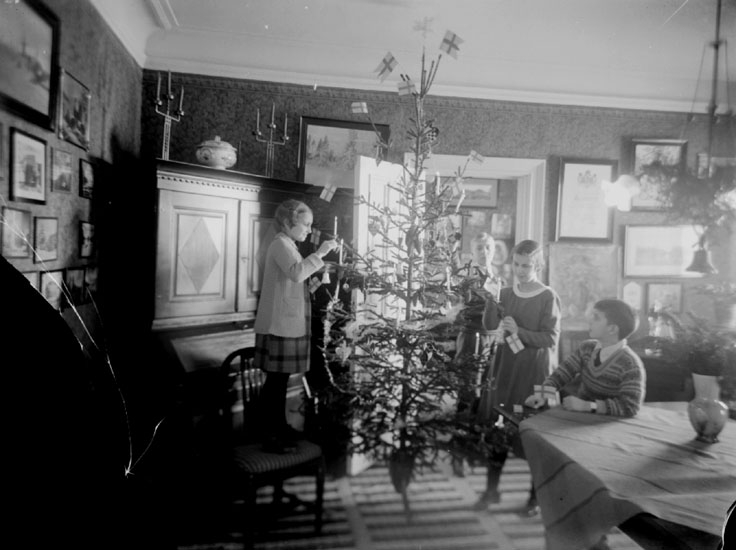 Rumsinteriör, fyra barn runt julgranen på juldagen.
Fotograf Sam Lindskogs hem.
