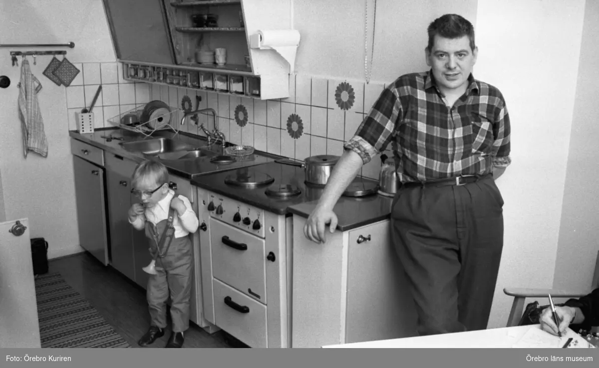Dagmamma, manlig 11 juni 1970

Det står en manlig dagmamma vid spisen i köket, och en pojke som har glasögon. Pojken har en leksakstrumpet i handen.
