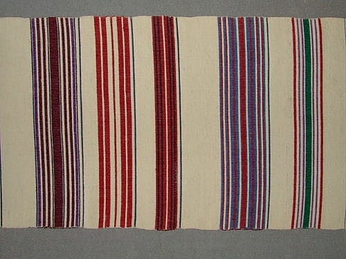 Bolstervarsprov i olika randningar och olika färgställningar. Varp i bomull och inslag i ullgarn. Vävdes för en inventering på 1940-talet.