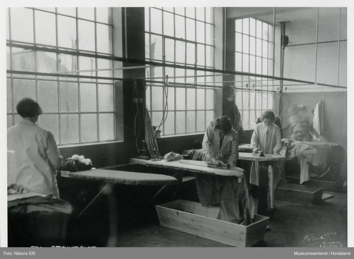 Kvinner på arbeid i strykeriet ved Wilhelm Kahrs Kemisk Renseri & Farveri, Bergen.