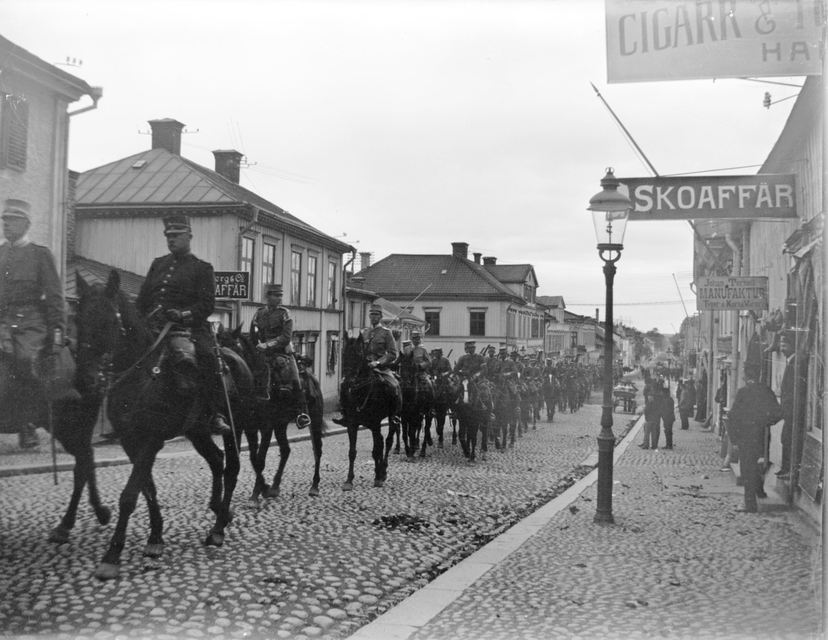Militärtrupp på häst uppför Kungsgatan, Enköping, sett från Kungsgatan 16 mot söder