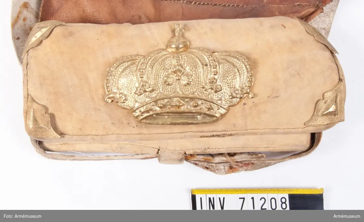 Grupp C:II.
Samhörande: rem. Locket prytt med kunglig krona av messing; 1700-talet.
Inuti patronväskan finns en bleckplåtsinsats med rum för 12 patroner av ca 18 mm kaliber.