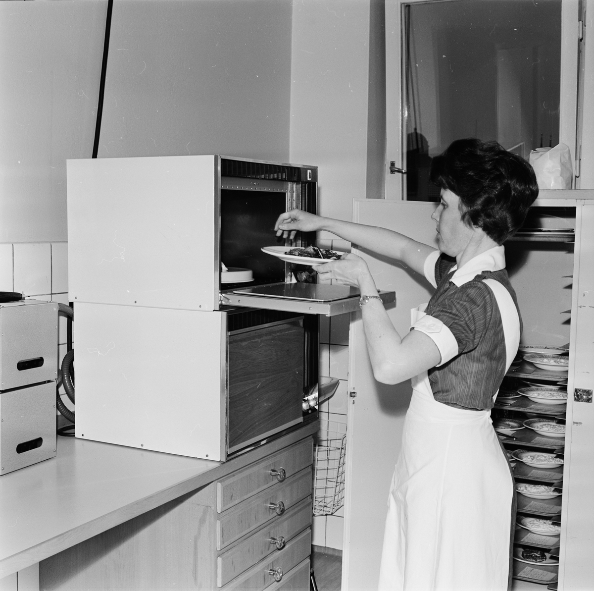 Sjukvårdspersonal värmer mat i mikrovågsugn i köket på Öronkliniken, Akademiska sjukhuset.