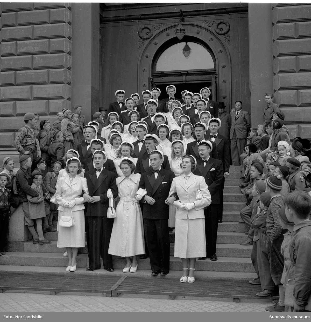 Studentexamen 1951. Studenterna på läroverkets trappa och tågandes utefter Köpmangatan mot stora torget.