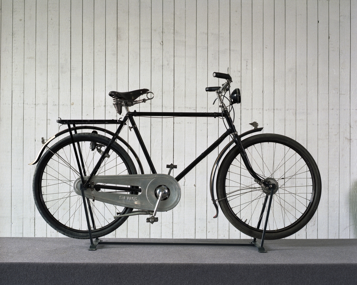 Cykel med vägmätare BT. och tillbehörspakethållare. Sfinx kjedjeskydd i aluminium. F&S (tyskt) framnav och SA (engelskt) baknav märkt: 2 B6.
Tillbehör: Två packväskor av smärting som innehåller en verktygsväska av svart läder, två fasta nycklar, en skruvmejsel, en torkduk, en plåtask för gummirep, märkt: "Romac cycle repair oitfit 4" Junior", en svensk flagga typ vinkel, längd: 320 mm, bredd: 140 mm, en tygpåse, en vit tygpåse, hemgjorda mörkläggningsdetaljer för Hermescykeln, ett till framlyset och ett till baklyset gjorda i papp från andra värdsgrigets tid ( tillhör den Hermes cykel som T Wilner år 1970 överlät till Tekniska Museet), en pappask: reparationsask av svensk tillverkning, en gul tvålask märkt:"Shell" med gul tvål i samt en handduk, vit med röd dekor.