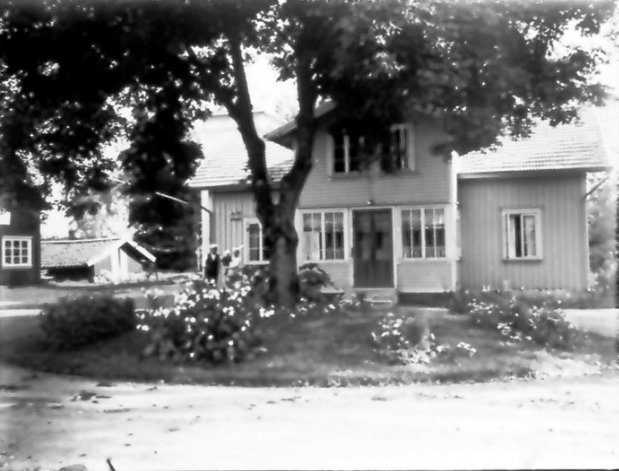 Floby mejeri, bostadshuset. Mejerist Göran Johansson med fru Signe och sonen Halvard.Till vänster Hofflanders möbelaffär. Vid trädet bildades Floby IF 1925.