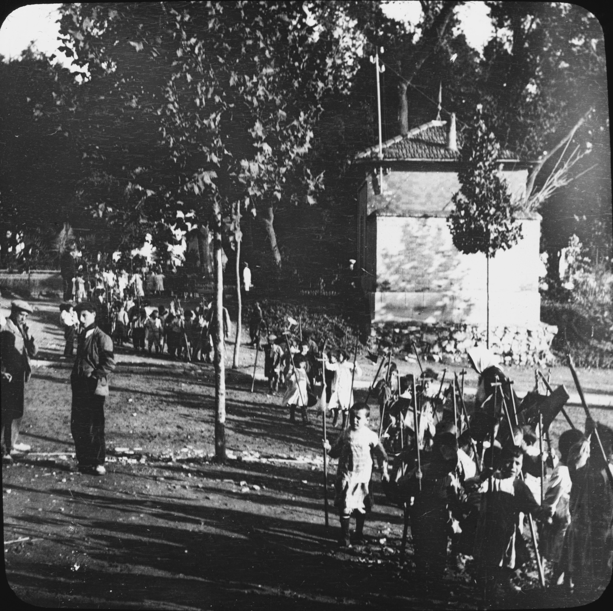 Skioptikonbild med motiv av barn i parad, bärande på kors.
Bilden har förvarats i kartong märkt: Granada 1910. Granada. N:12. Text på bild: "Repetilion tell feittog".