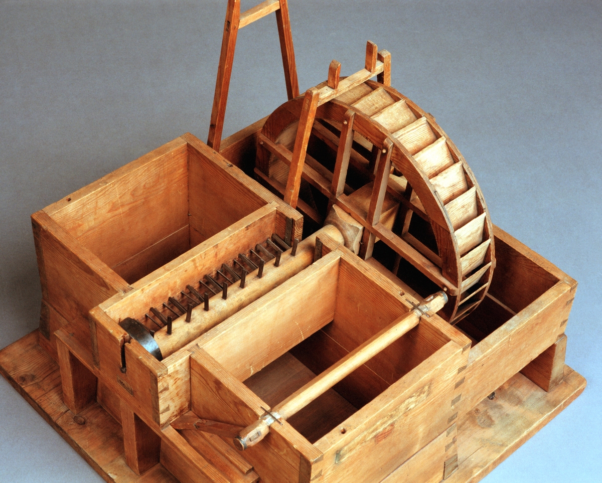Modell av tegelslagningsmaskin. Text på föremålet: "XVI.B.1. E-b-5 N:o 179. E.b.1.5. Murbruks och Lerbråka".
