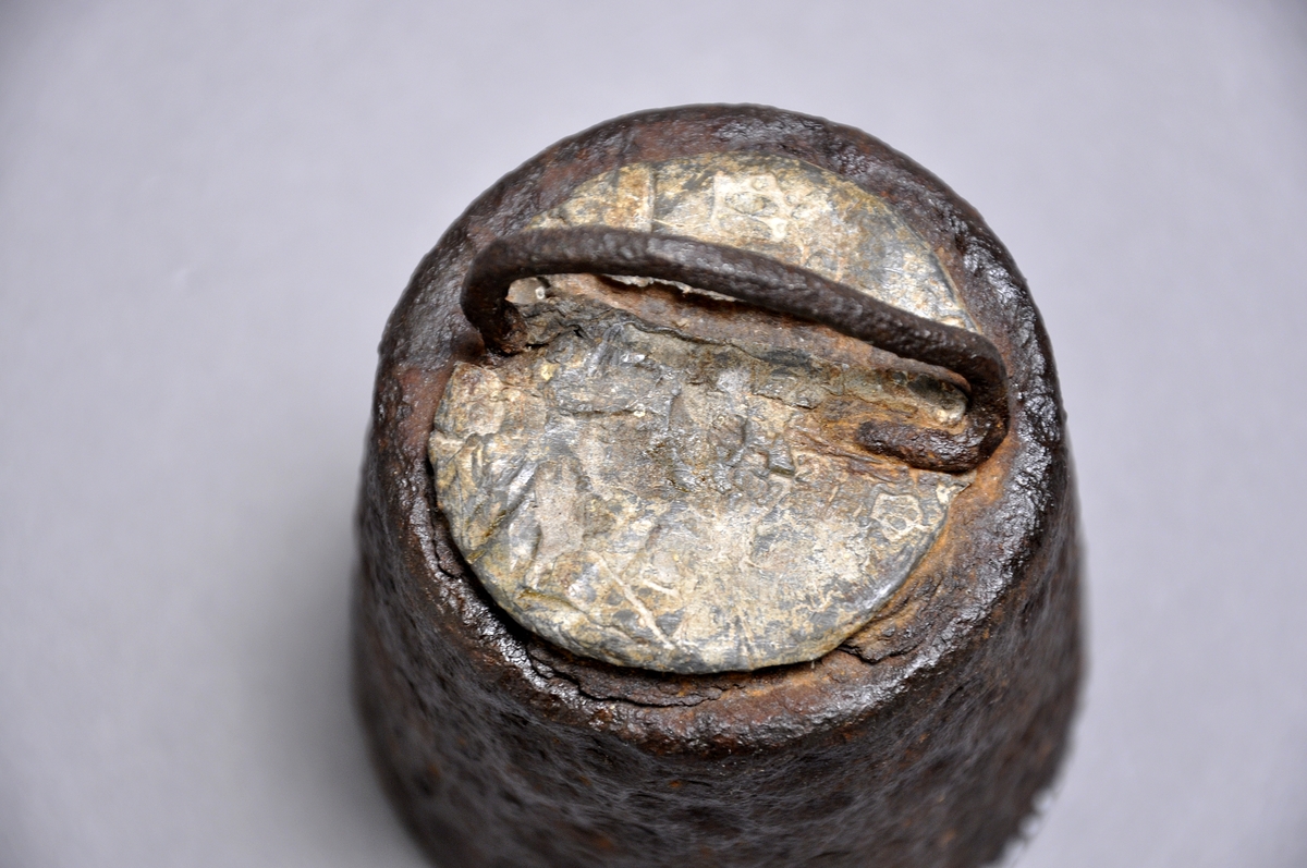 Vikt av järn, rund ock konisk med handtag Märkt 5 skålpund  krönt      1883 Krönt märkt under med ett M Krönt