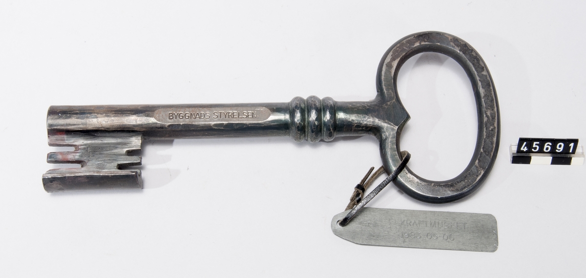 Nyckel av järn, märkt "Byggnadsstyrelsen", med bricka märkt "Elkraftmuseet 1983-05-06".