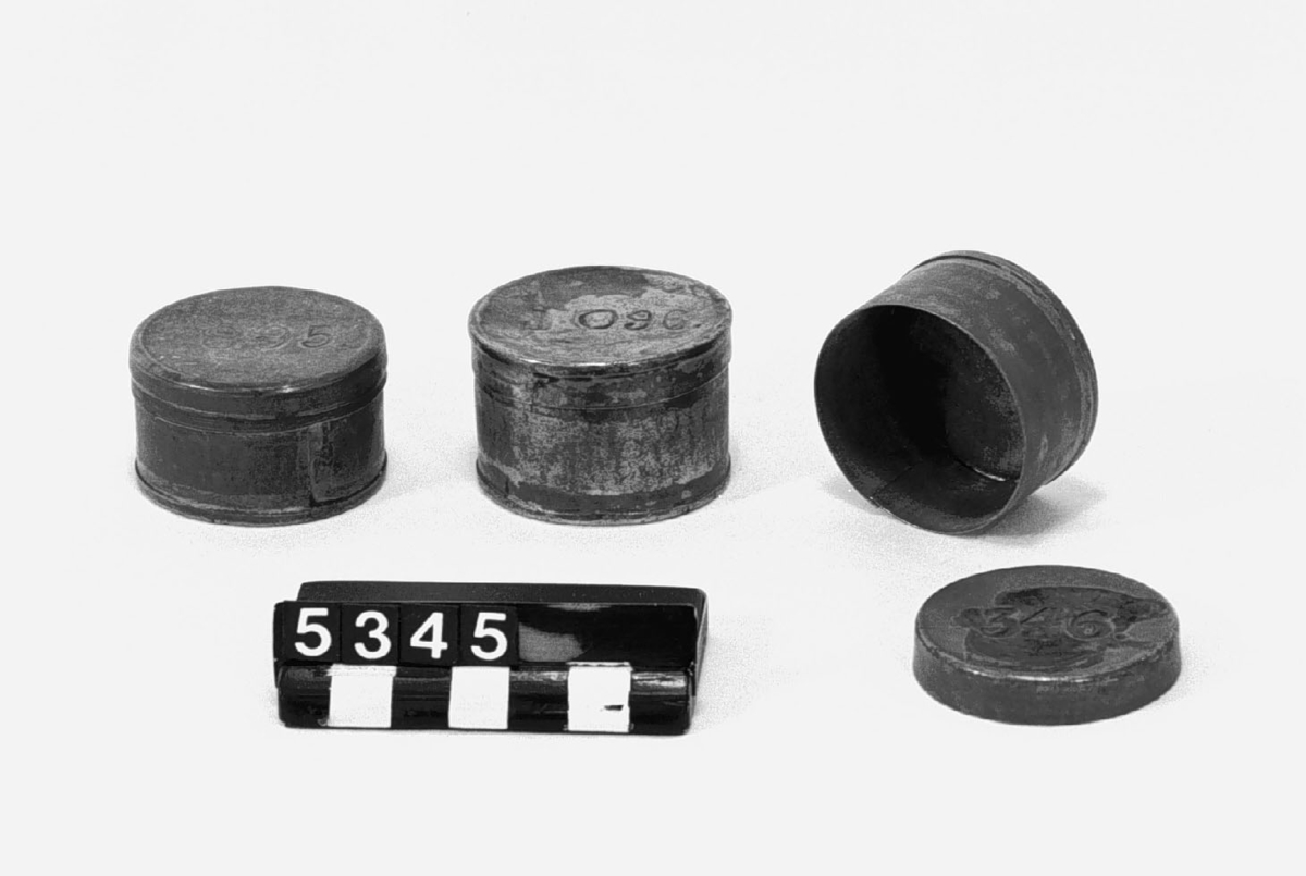 Tre. runda askar/dosor, som använts vid utdelning av avlöning sannolikt under 1700-talet. På locket är tydligt graverat 346. Materialet är tunn järnplåt, troligen bleckplåt. I en av dosorna en arbetssedel. Höjd: 26.30 mm, diameter: 43 till 45 mm.