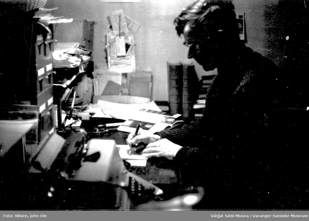 Portrett av John Ole Nilsen hjemme i Bunes, han sitter i kontorkroken sin og arbeider. 1966.