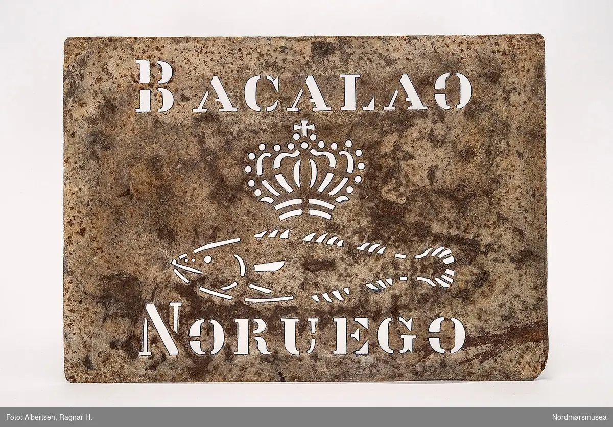 Rektangulær jernblikksjablon med tekst: "BACALAO NORVEGO", krone og fisk midt på sjablonen.