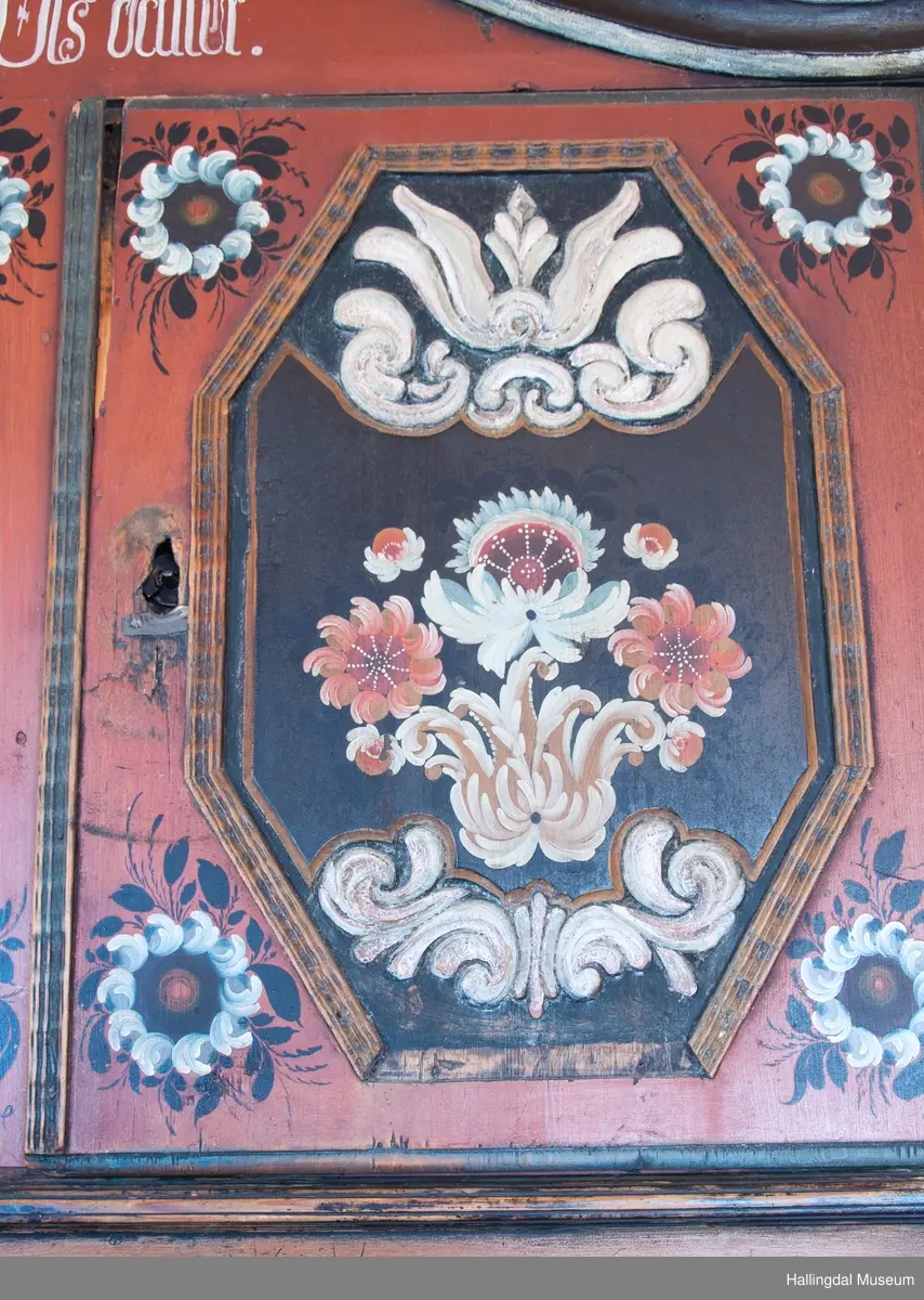 Delene festet med trenagler.  Høy, buet gavl med fremspringende kronlist som øverst har gjennomskåret omvendt hjerte.  Kronlist har hulkil og vulst, og fortsetter på sidene av overskap.  Overskapets front delt i tre felt, med en dør i hvert sidefelt.  Dørene er hengslet til skapets sider.  Hengslene av jern og festet på overkant og underkant av skap og på overkant og underkant av ramme.  Dørene har to profilerte labanker i spor på innsiden.  Låskasetter innfelt i dørblad.  Låsskiltene mangler.  Nøkkel med kløverformede hoder, profilert. En skillevegg midt i overskapet.  To hyller i hvert skap.  Dørene og midtfelt har speil med fyllinger og utskjæringer, akantus i relieff på speilflatene.  Dørspeilene er ovale, åttekantede.  Speil i midtfelt har tilnærmet korsform.  Skjenken har utskåret forplate, i tunger.  Under midfelt får forplaten helt ned til skjenkeplate med gjennombrutt hjerte.  Halvrunde åpninger i hver side. ..........