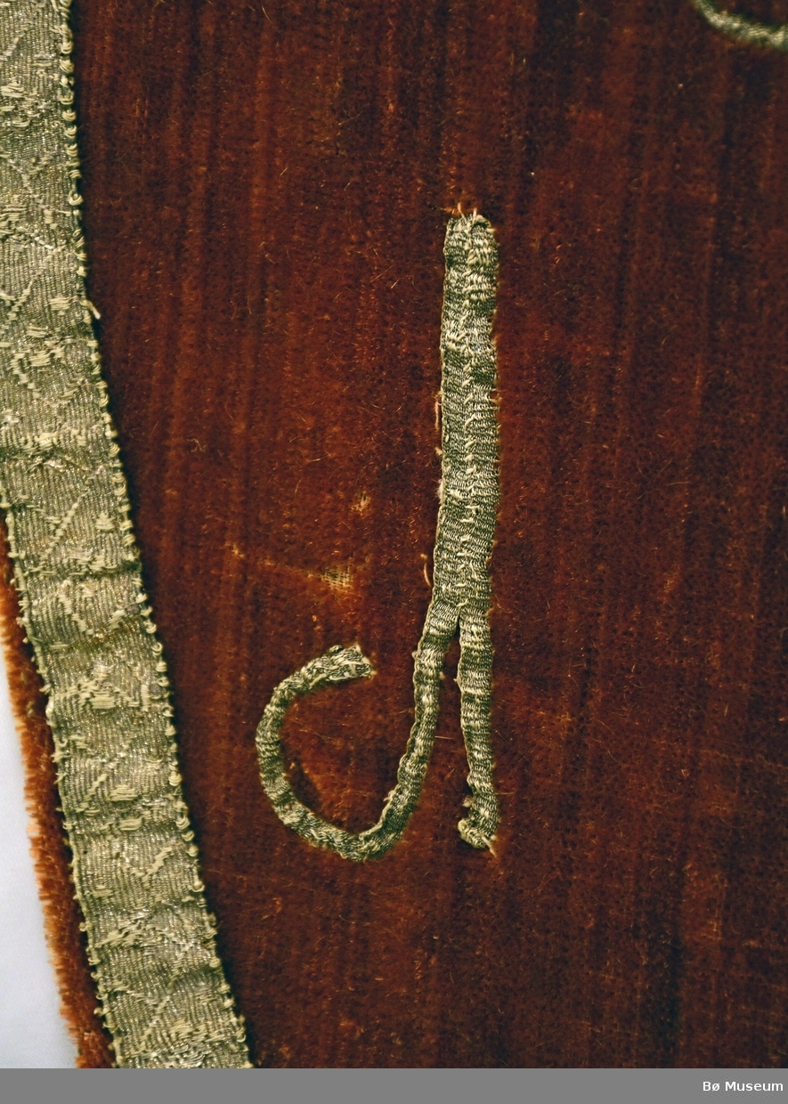 Kors i silke og sølvband, sølvband langs kant.