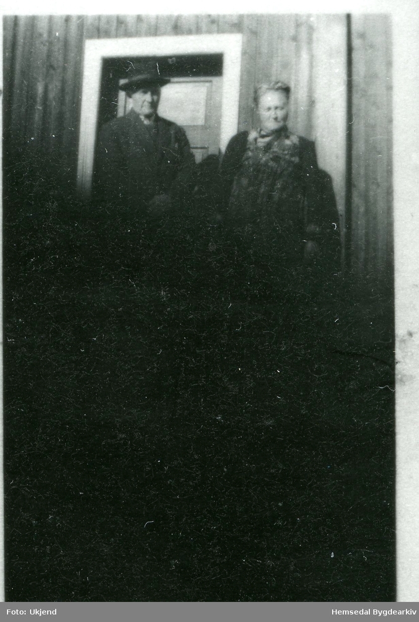 På stovetrappa (stuggutrøppe, dialekt) står Lars Eikre (1866-1958) og kona Margit, fødd Grøthe (1879-1956).